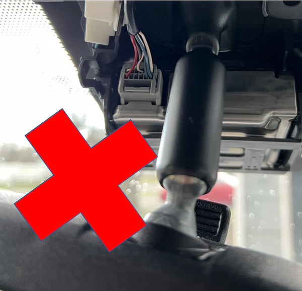 Car interior with a red cross mark indicating incorrect placement or action.