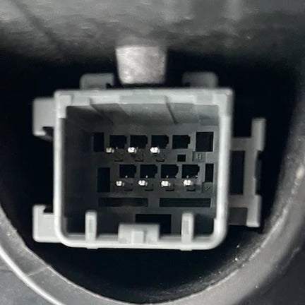 Close-up of a car diagnostic connector with pins on a dark background