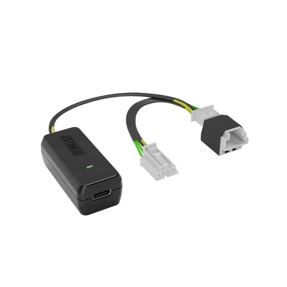 Dongar hardwire module with glowing green light and off-white connectors revealing copper terminals, wired with yellow and green conductors for clear visibility