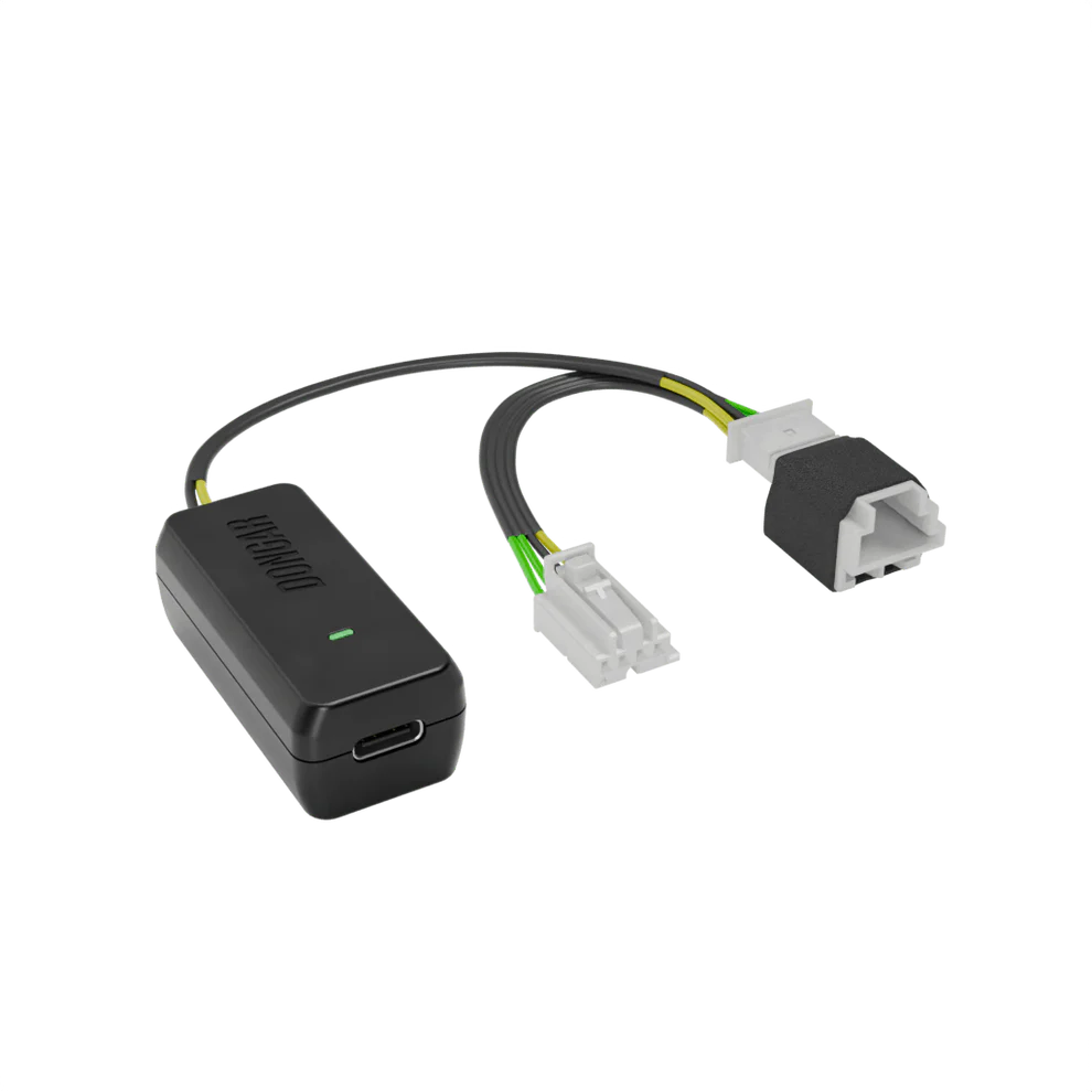 Dongar hardwire module with glowing green light and off-white connectors revealing copper terminals, wired with yellow and green conductors for clear visibility
