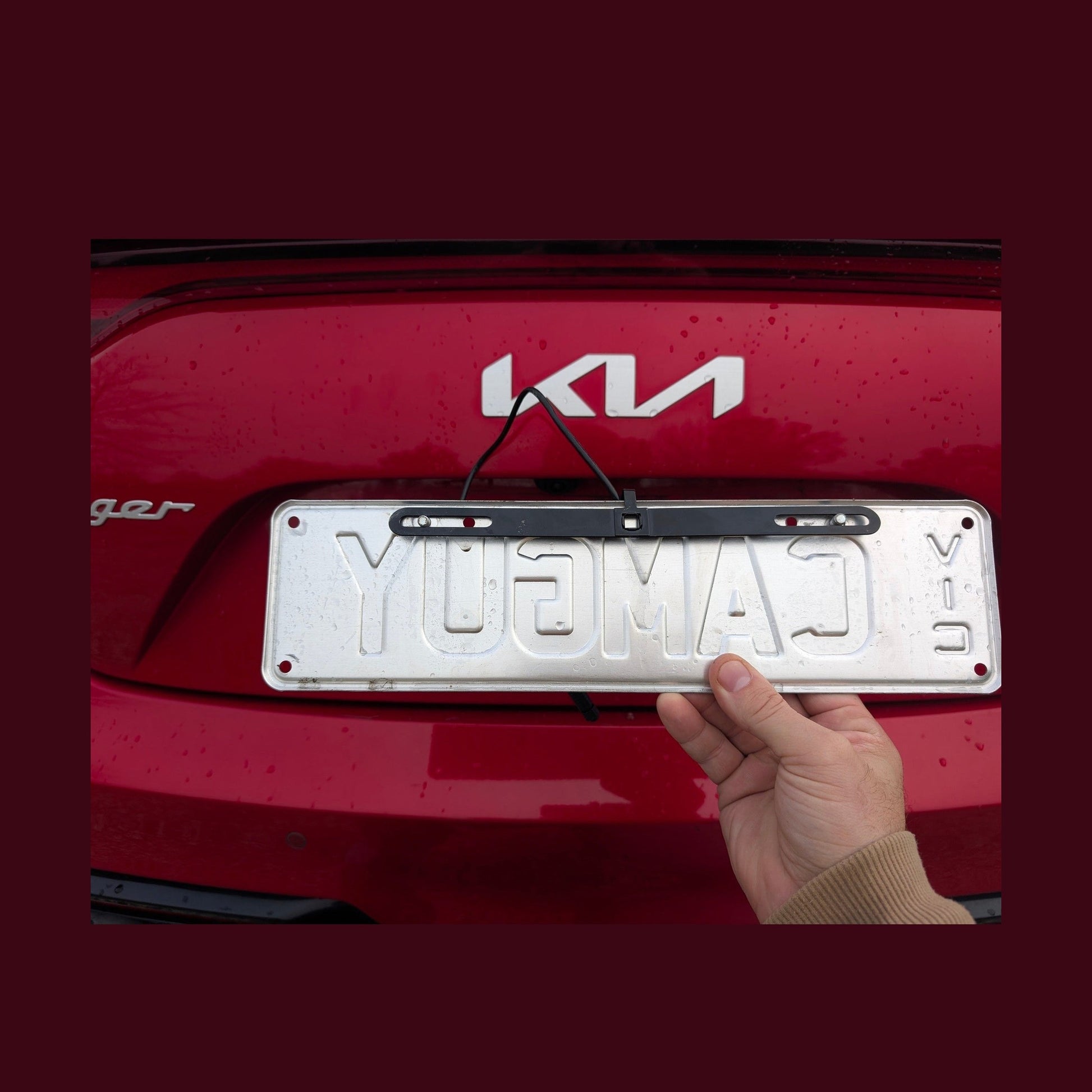 Hand installing Wolfbox bracket onto silver Australian number plate
