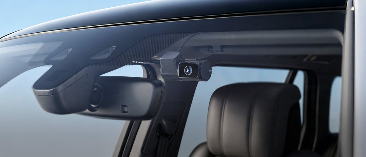 VIOFO T330T screenless dash cam mounted discreetly on car windshield near rearview mirror
