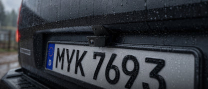 Waterproof VIOFO rear dash cam mounted above license plate in rain demonstrating weather resistance