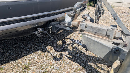 Coiled extension cable connecting vehicle bumper to trailer hitch