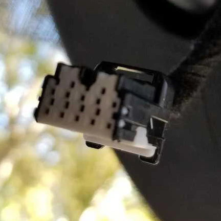 Close-up of a car wiring connector with a blurred natural background