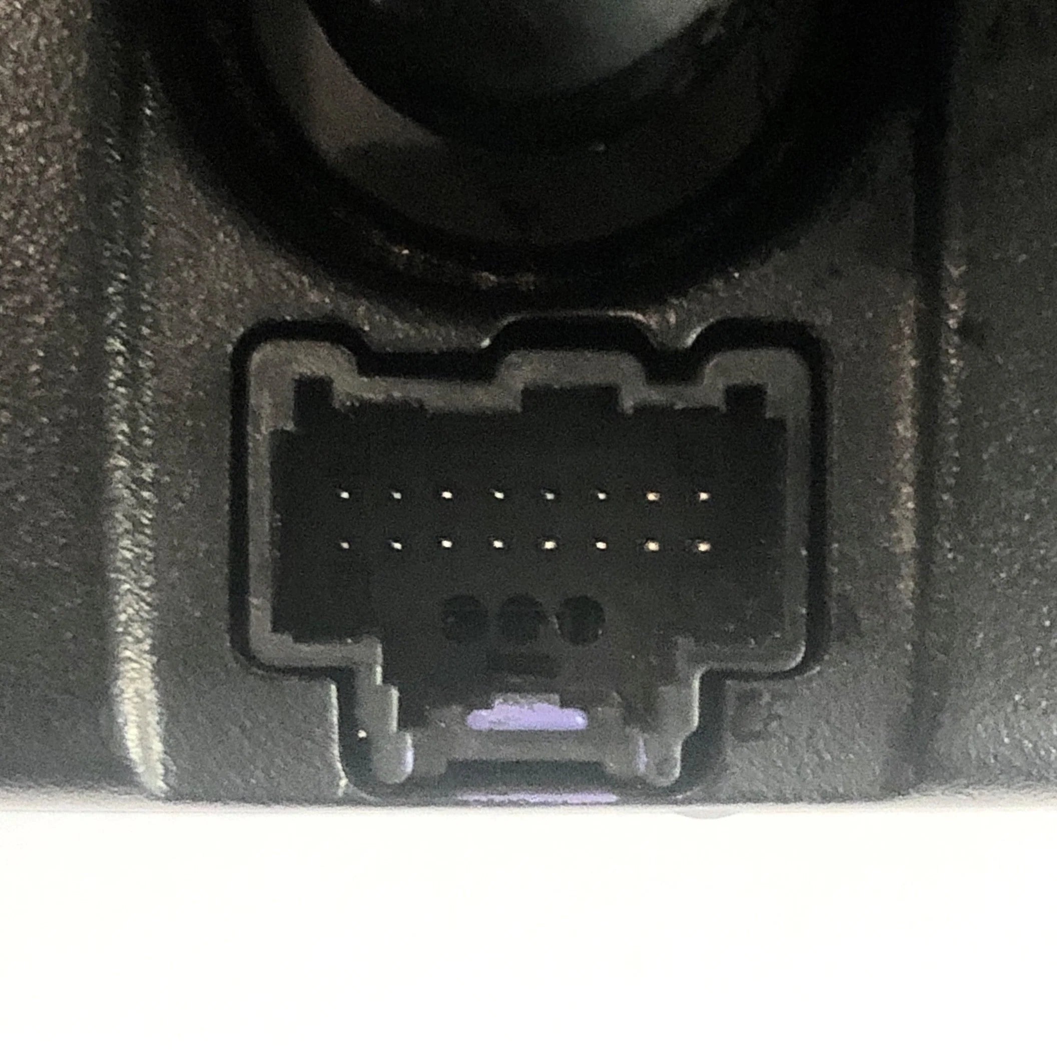 Close-up of a black plastic component with a socket on a gray background