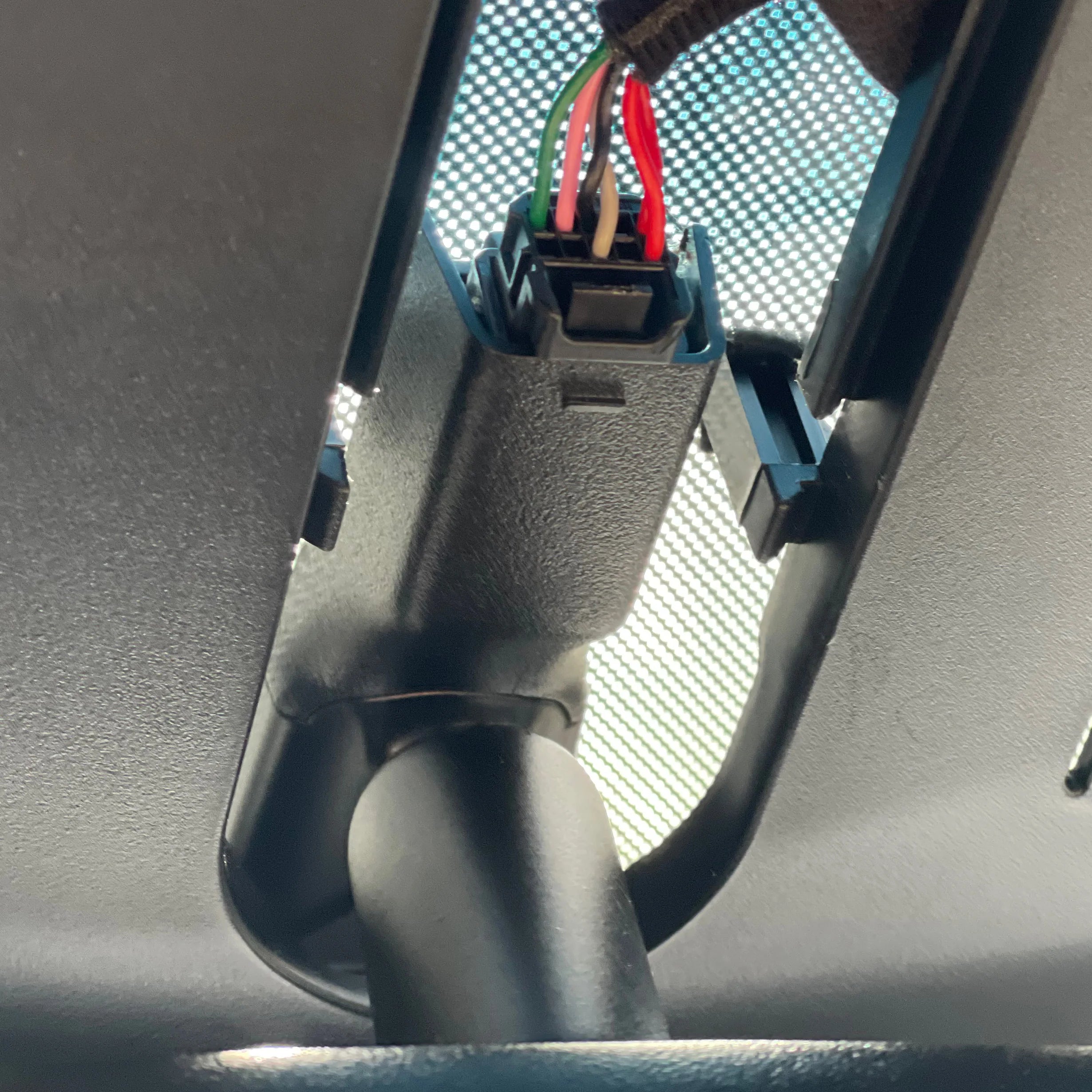 Close-up of a car's sun visor with wiring and connectors.