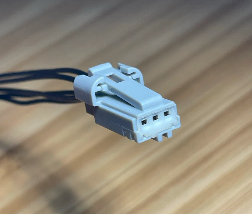 Gray electrical connector with wires on a wooden surface